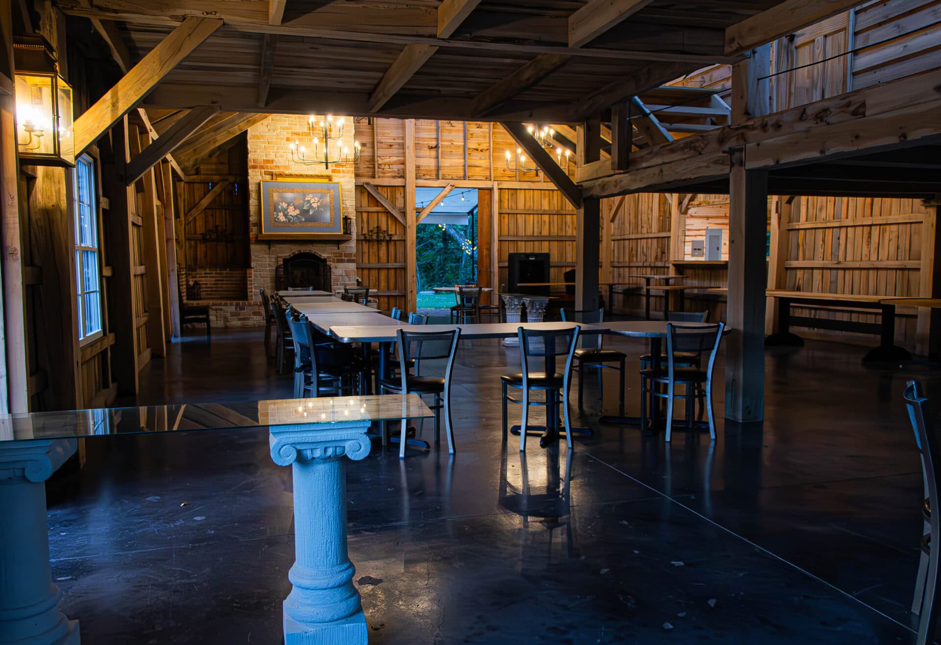 Elegant rustic interior of Belle Stone Venue with wooden beams, cozy fireplace, and string lights, perfect for wedding receptions and private events with charming ambiance.