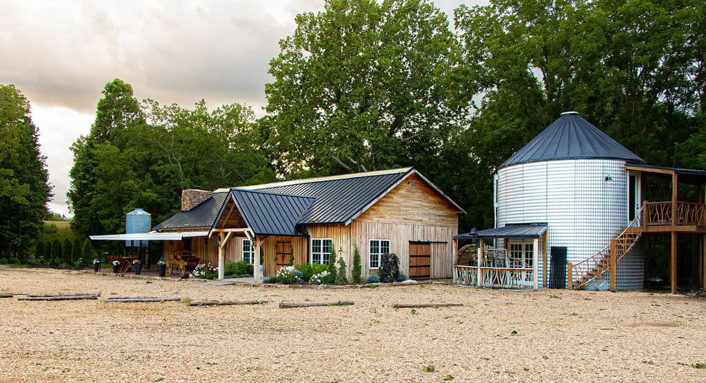 Rustic barn and silo at Belle Stone Venue, perfect for outdoor wedding ceremonies and events in a scenic countryside setting. Beautiful farm-style venue with natural surroundings and charming rustic architecture.