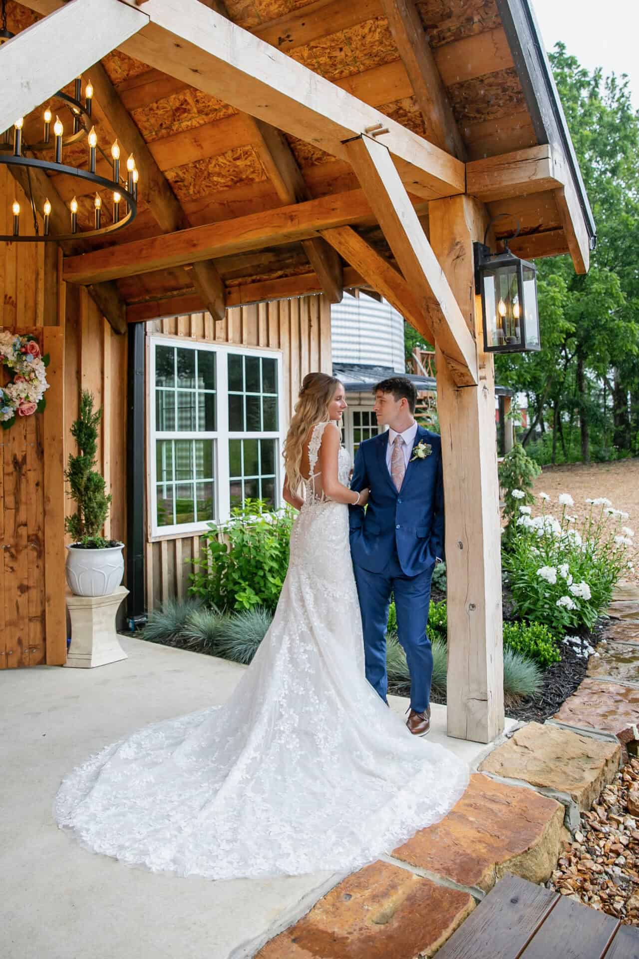 Elegant bride and groom on wedding day at Belle Stone Venue with rustic wooden architecture, lush garden, and romantic ambiance. Ideal for outdoor wedding celebrations and receptions.